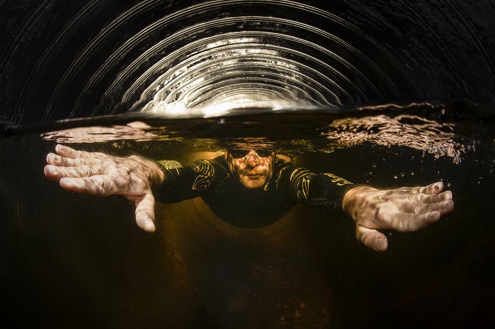 Mies sukeltaa tunnelissa kädet ojennettuina eteen